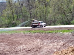 Truck hydroseeding along road